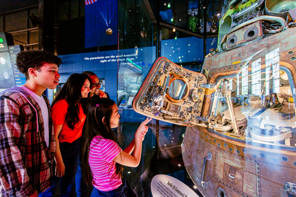 Visitors looking at the Apollo 16 command module up close