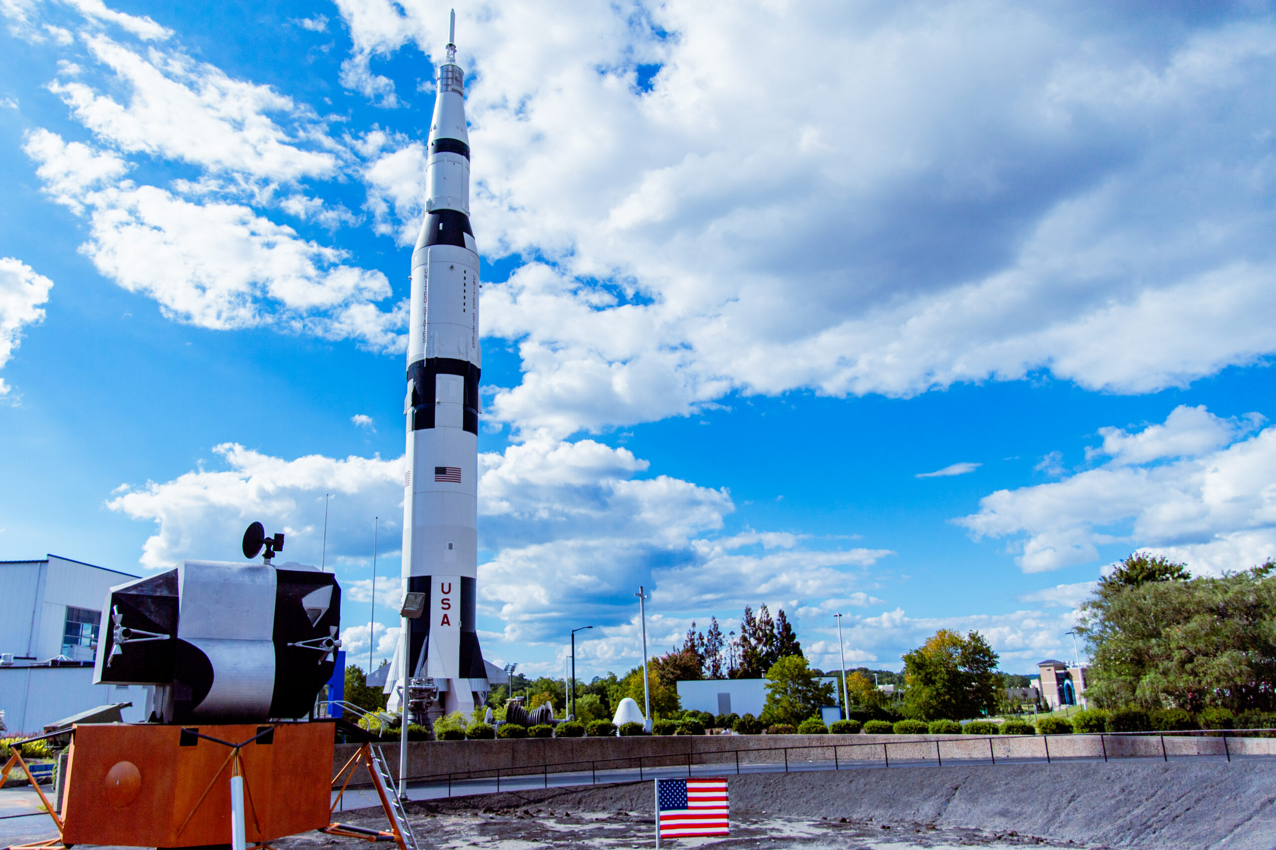 Saturn V rocket standing in Rocket Park with a lunar module in front