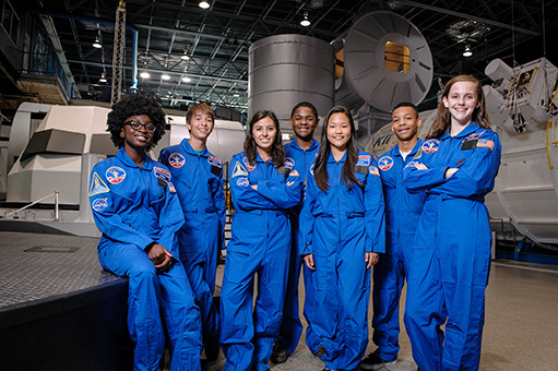 older picture of campers in their blue flight suits on the mission control floor