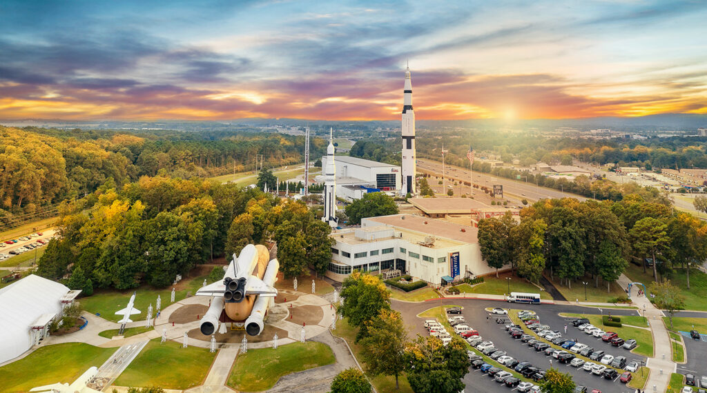 Aerial view of the U.S. Space & Rocket Center campus at sunset, with the Saturn V and Space Shuttle Pathfinder