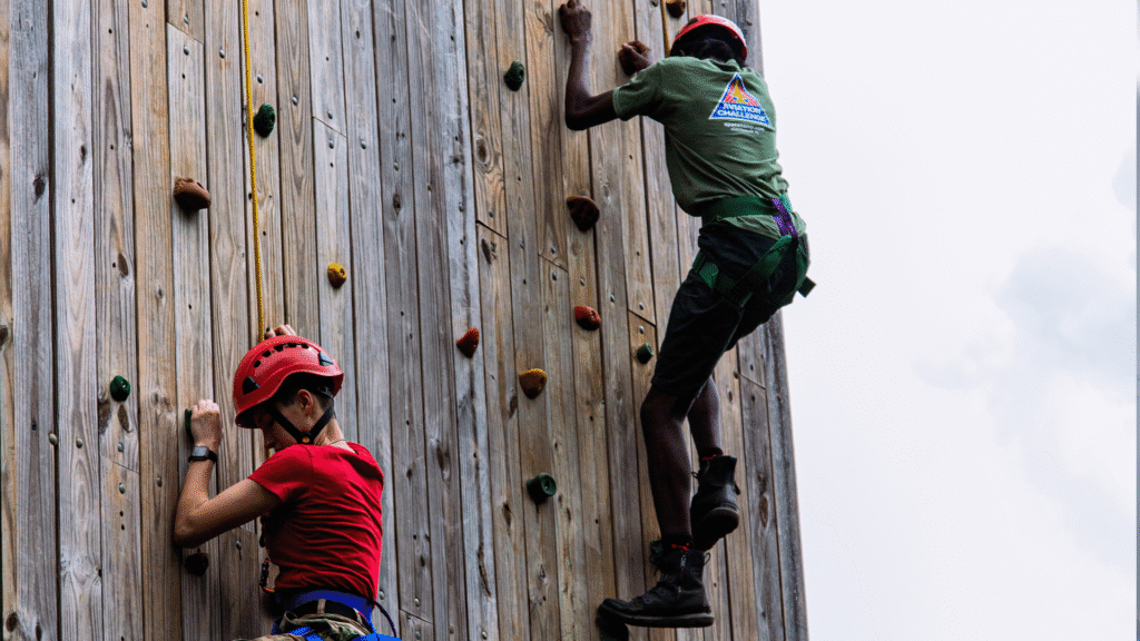 two individuals on the climbing wall used during aviation challenges.