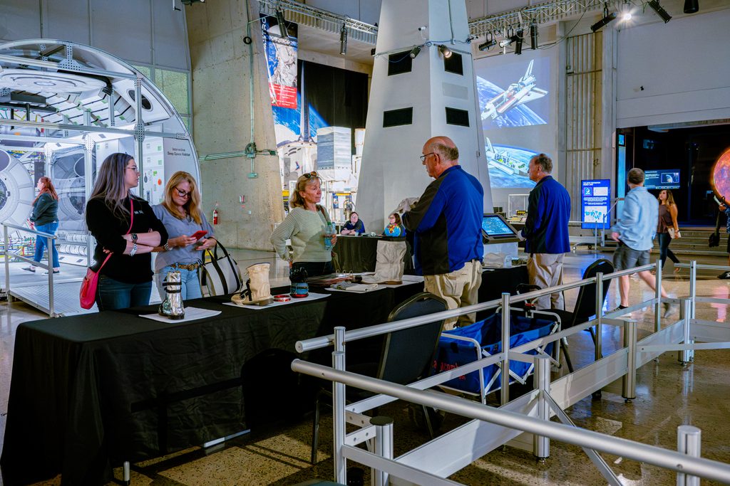 Staff informing a group of people about World Space Week in the Atrium