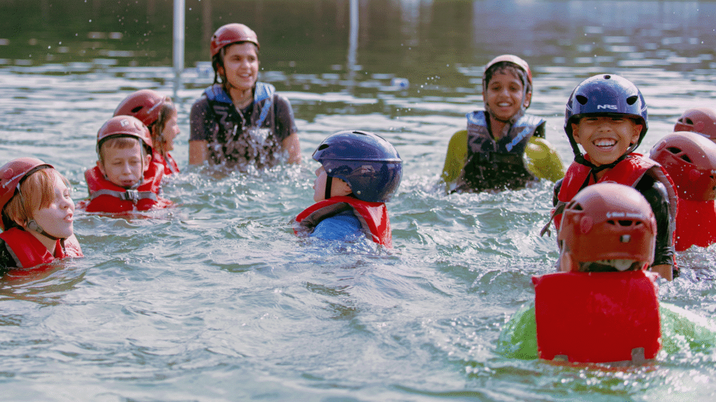 Mach I campers in helmets and life vests in the water