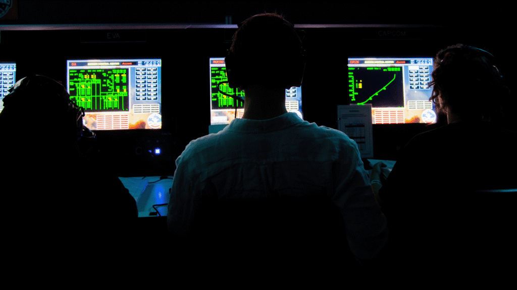 Advanced Space Academy Elite trainees silhouetted at Mission Control consoles